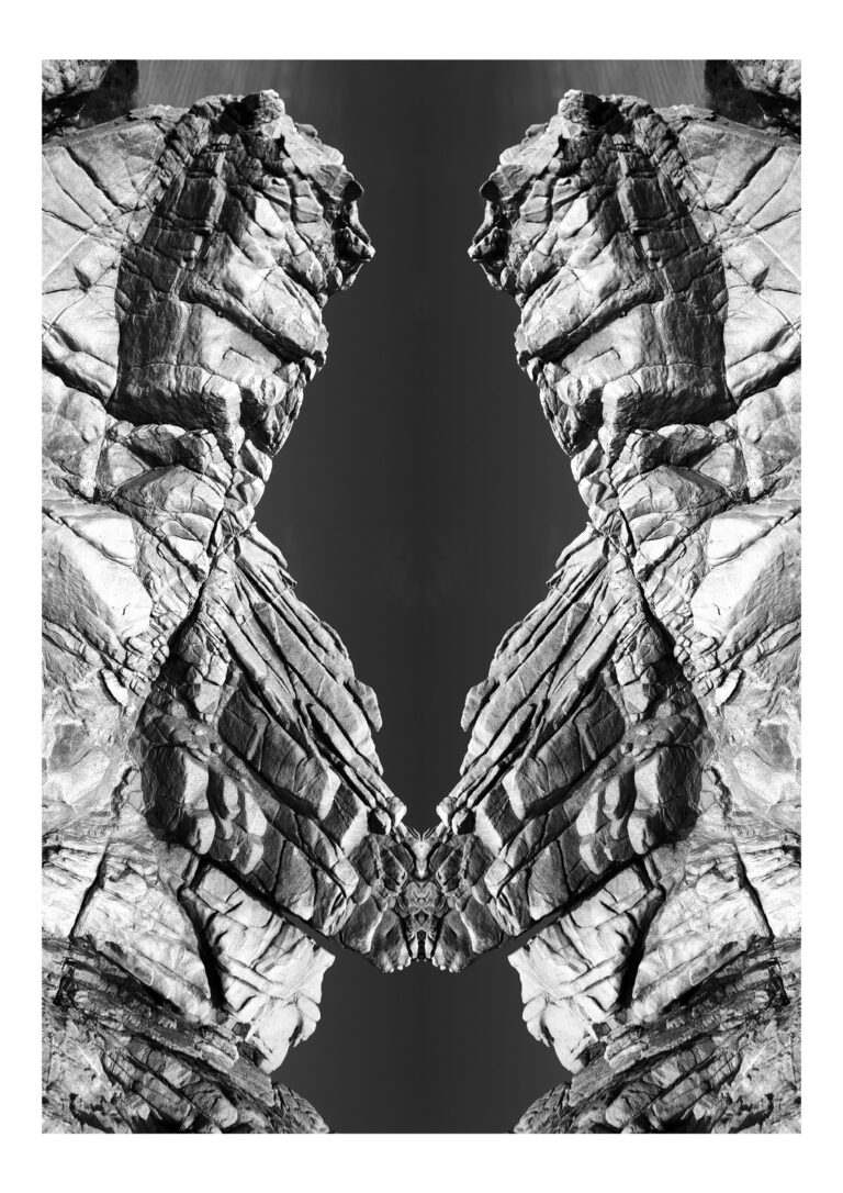Yakamoza - Black and white abstract photography of big rock formation, put in vertical symmetry; reminds of brutalist architecture