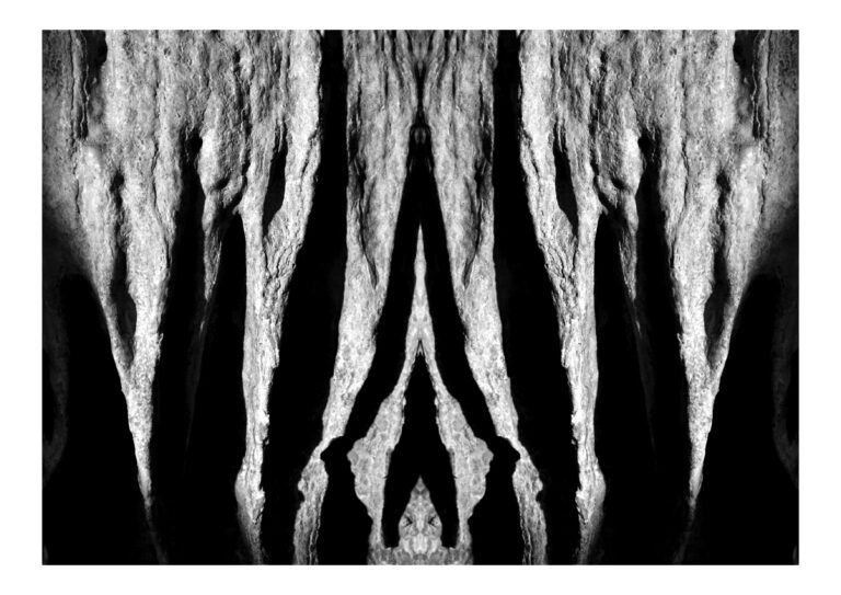 Yakamoza - Black and white photography (landscape format) of stalactites put in vertical symmetry