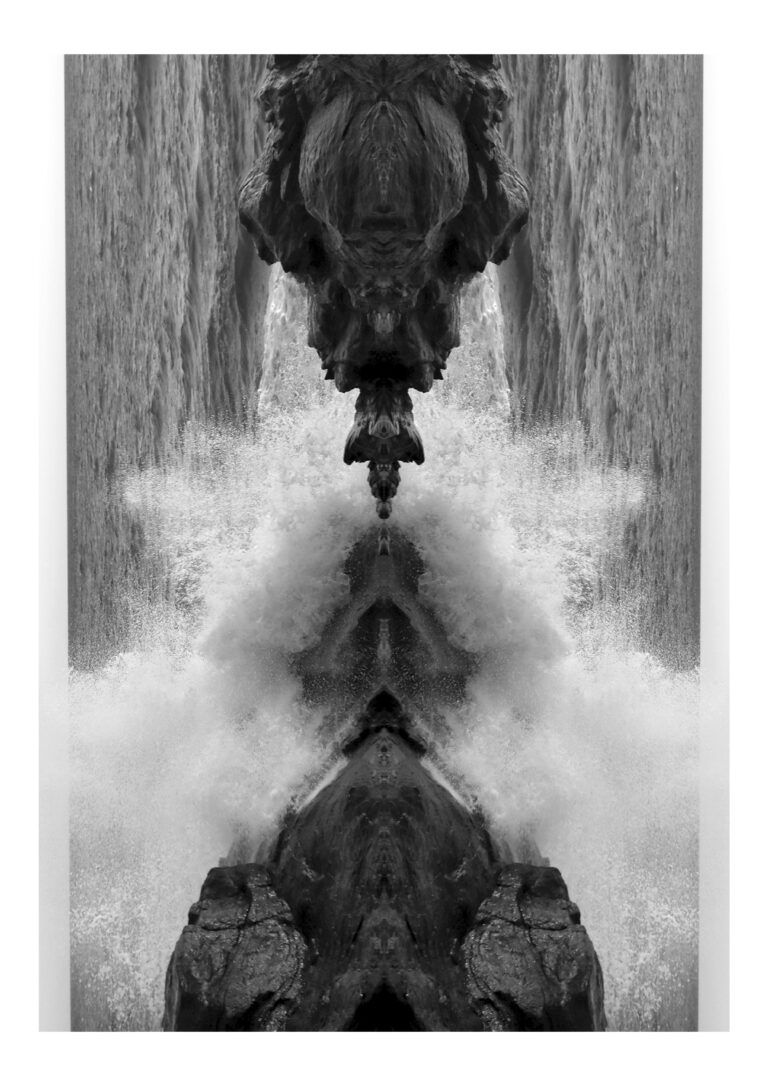 Yakamoza - Black and white photography of ocean wave splashing against rocks, put in vertical symmetry, giving it a sculptural totem look